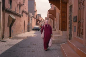 a woman walking down a street carrying a bag