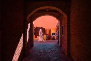 A person walks through a brick archway.