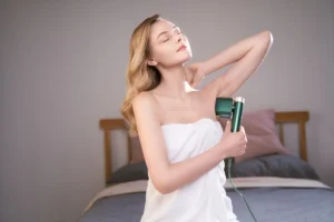 Captured in a serene bedroom setting, a model uses a laser hair removal device, illustrating the ease of achieving smooth skin at home.