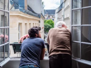 father and son looking at a parisian street through the window
