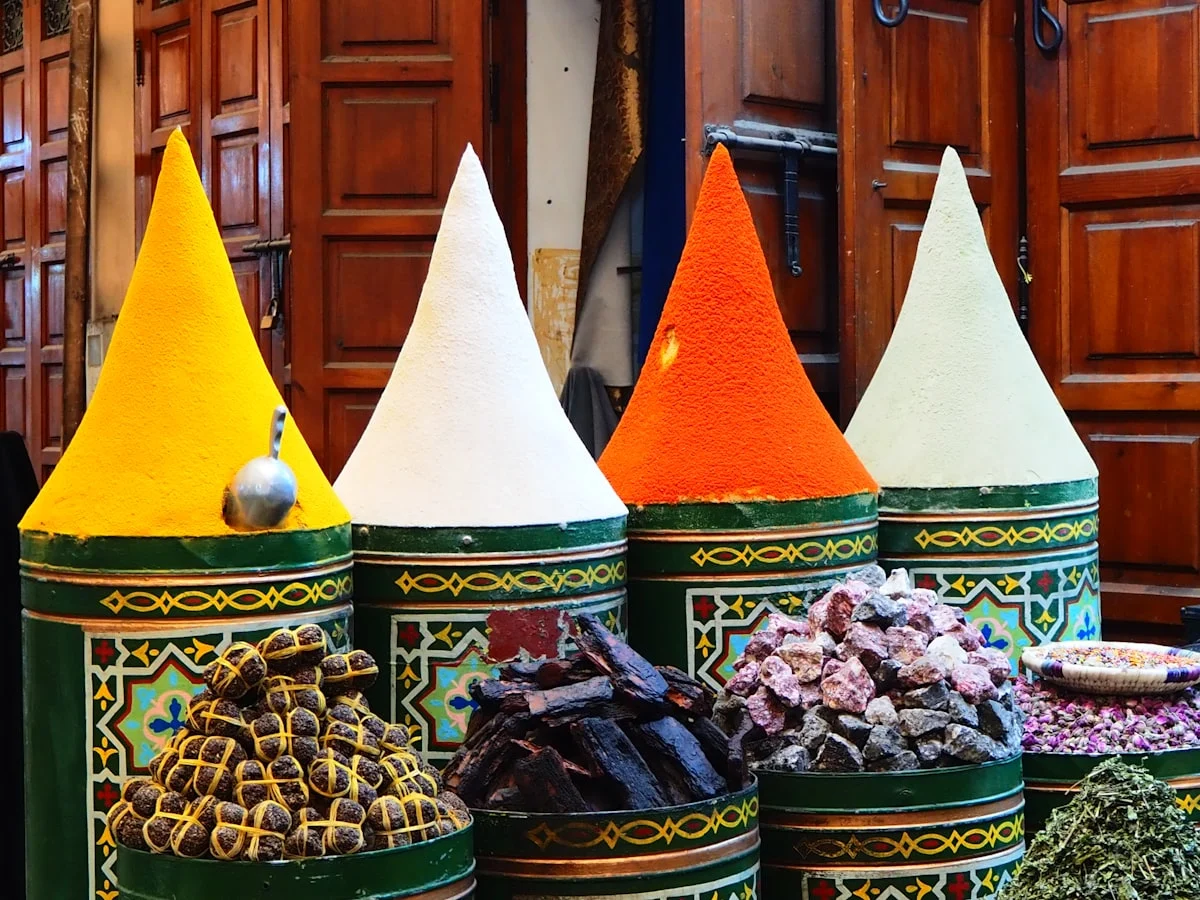 Colorful spices displayed in conical piles at a market.